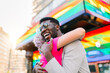 © MyMicrostock/Stocksy - Smiling black man embracing unrecognizable beloved near colorful building
