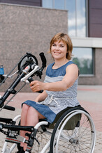 Cheerful Woman On Electric Wheelchair With Handbike