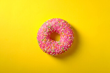 Sweet pink donut on yellow background