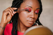 © AD Photography/Stocksy - Beautiful black woman applying make up