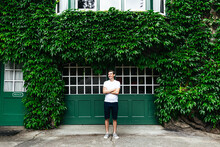 Portrait of male in front of leafy green wall