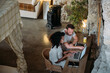 © David Prado/Stocksy - Diverse couple using laptop in rock house
