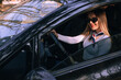 © Ivan - Young beautiful smiling girl driving a car.