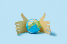 Two Paper Hand Protect Craft Earth's Globe.
