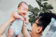 © MaaHoo Studio/Stocksy - Asian father lifting baby son