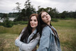 © Rob and Julia Campbell/Stocksy - Teenage sisters posing together in a field.