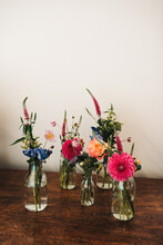Small Vases With Wild Flowers On A Dark Wooden Table