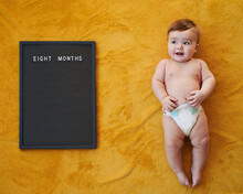 Shirtless Baby Near Board With Writing