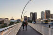 © Gillian Vann/Stocksy - 2 young woman walking across a bridge in the afternoon
