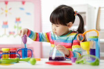 young girl playing color sorting and fine motor skill toy at home