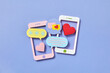 © Yaroslav Danylchenko/Stocksy - Two papercraft smartphones and chats cloud icons.