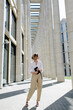 © Sergey Narevskih/Stocksy - Confident anonymous woman with tablet near business center on city street