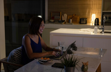 Woman working from home at night - looking at illuminated screen