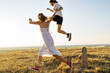 © Ivan Ozerov/Stocksy - Cheerful young couple having fun in summer field