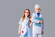 © oksix - Cute boy and girl in medical uniform playing like doctors