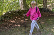 © Hakan & Sophie/Stocksy - Vibrant elderly woman walking in nature using trekking poles