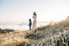 Mother And Daughter In Nature Above Clouds