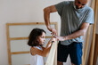 © Jimena Roquero/Stocksy - Kid helping her father assembling a furniture.