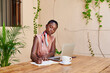 © Ivan Gener/Stocksy - Young woman working at a table on her patio