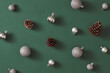 © Maki Company Limited/Stocksy - Pattern made of white balls and pine on green background