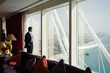© Floris Productions/Stocksy - Businessman Looks out Window in Dubai
