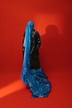 Woman Wearing A Faux Leather Coat And A Blue Plastic Sheet