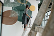 © Milles Studio/Stocksy - Female artist creating abstract ornament on wall