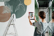 © Milles Studio/Stocksy - Unrecognizable woman taking picture of painted wall