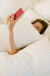 © Duet Postscriptum/Stocksy - Girl under pillow with smart phone