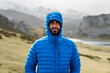 © Manu Prats/Stocksy - Adult sportsman wearing hooded jacket in foggy mountains