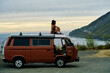 © Victor Bordera/Stocksy - Young traveller enjoying the beautiful views of the Californian coast from the top of a vintage campervan.