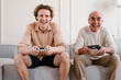 © Alina Hvostikova/Stocksy - Aged man with son enjoying video game at home