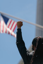 Woman With Her Fist In The Air In Front Of The American Flag