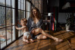© Tatiana Timofeeva/Stocksy - a young mother with a baby girl, curly hair woman with his beloved daughter