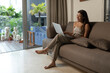 © Felix Hug/Stocksy - Young Pranakan Singaporean Woman on her sofa chatting and smiling
