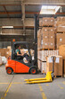 The worker transports freight using a forklift