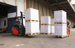 The worker transports freight using a forklift