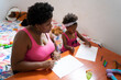 © Luis Velasco/Stocksy - Black Mother And Daughter Drawing On The Table.