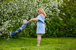 © Elena  - Mom and son in a blooming apple orchard in spring. A woman holds a child in her arms, plays and has fun with it.