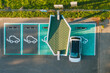 © Andrius Aleksandravičius/Stocksy - Drone aerial view of electric car parked in charging station