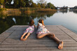 © Michela Ravasio/Stocksy - Little sisters lying together look at the lake