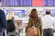 © Sean Locke Photography/Stocksy - Travel: Crowd Looks At Electronic Departure Board