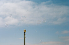 Soap Bubbles Flying In The Sky Next To A Lantern