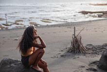 Woman Sitting At The Beach Alone Enjoying The Sunset