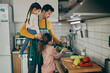 © Drazen - Single father and daughters cleaning vegetables while preparing food in the kitchen.