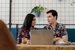 © Guaita Studio/Stocksy - Young happy couple having brunch and working studying in nice cafeteria looking at each other