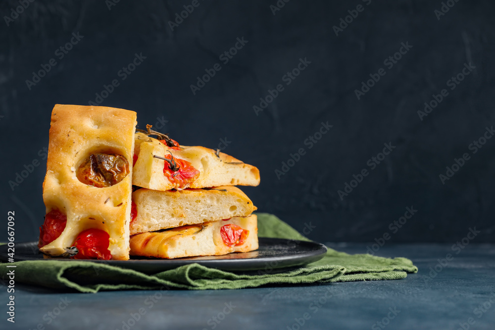 Plate with traditional Italian focaccia on dark background