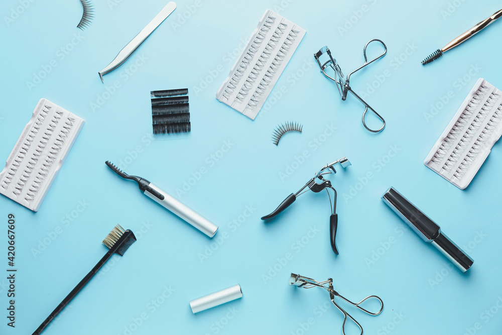 Composition with false eyelashes and tools on color background