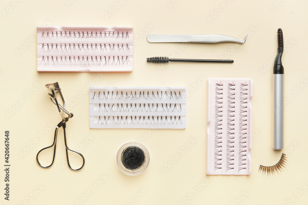 Composition with false eyelashes and tools on color background