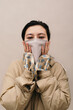 © Sergey Filimonov/Stocksy - Asian woman wearing protective mask